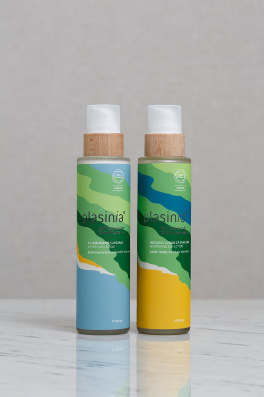 Two bottles of glasinia on a reflective surface with a neutral background