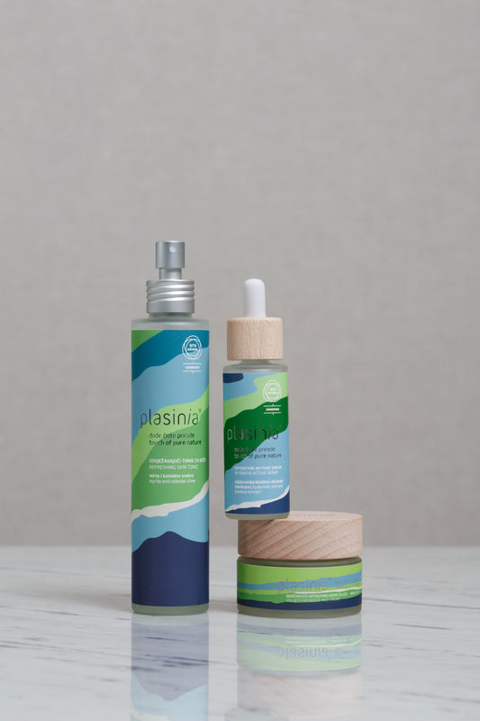 Three skincare products with green and blue packaging on a gray background